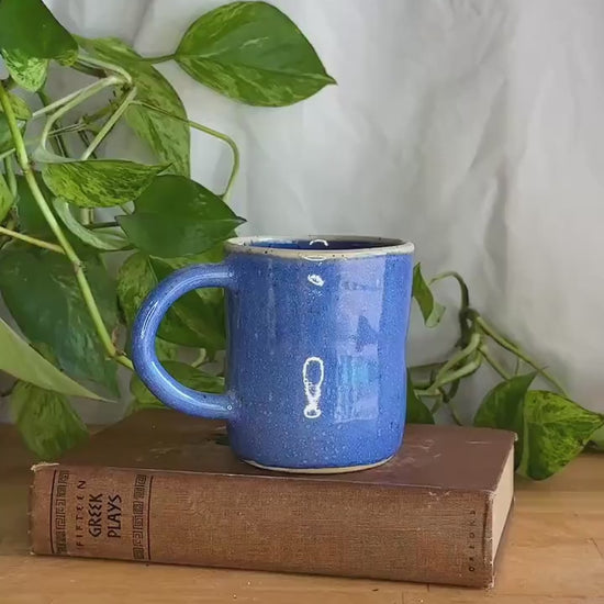 white rimmed blue speckled coffee mug